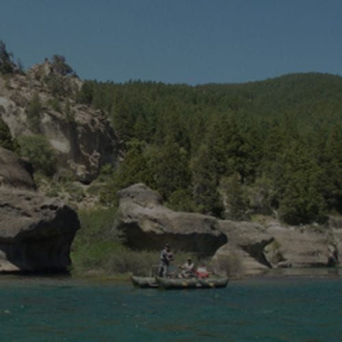 Guided fly fishing overnight charter on the Caleufu River, Bariloche, Patagonia, Argentina, featuring anglers on an all-inclusive multi-day trip catching brown and rainbow trout